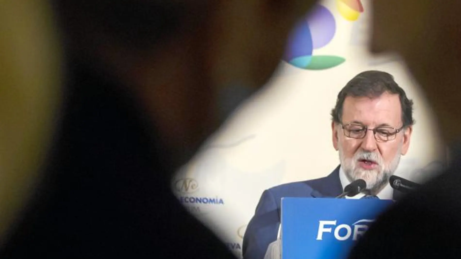 Cristina Cifuentes y Pablo Casado conversan con Rajoy al fondo