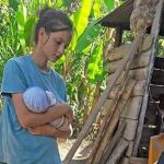 Patricia Aguilar, de 18 años, con su bebé en la finca de Perú donde ha vivido / Efe