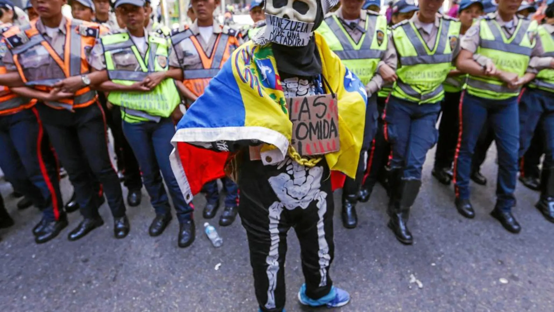 Un manifestante posa frente a los agentes de la Policía Bolivariana, ayer