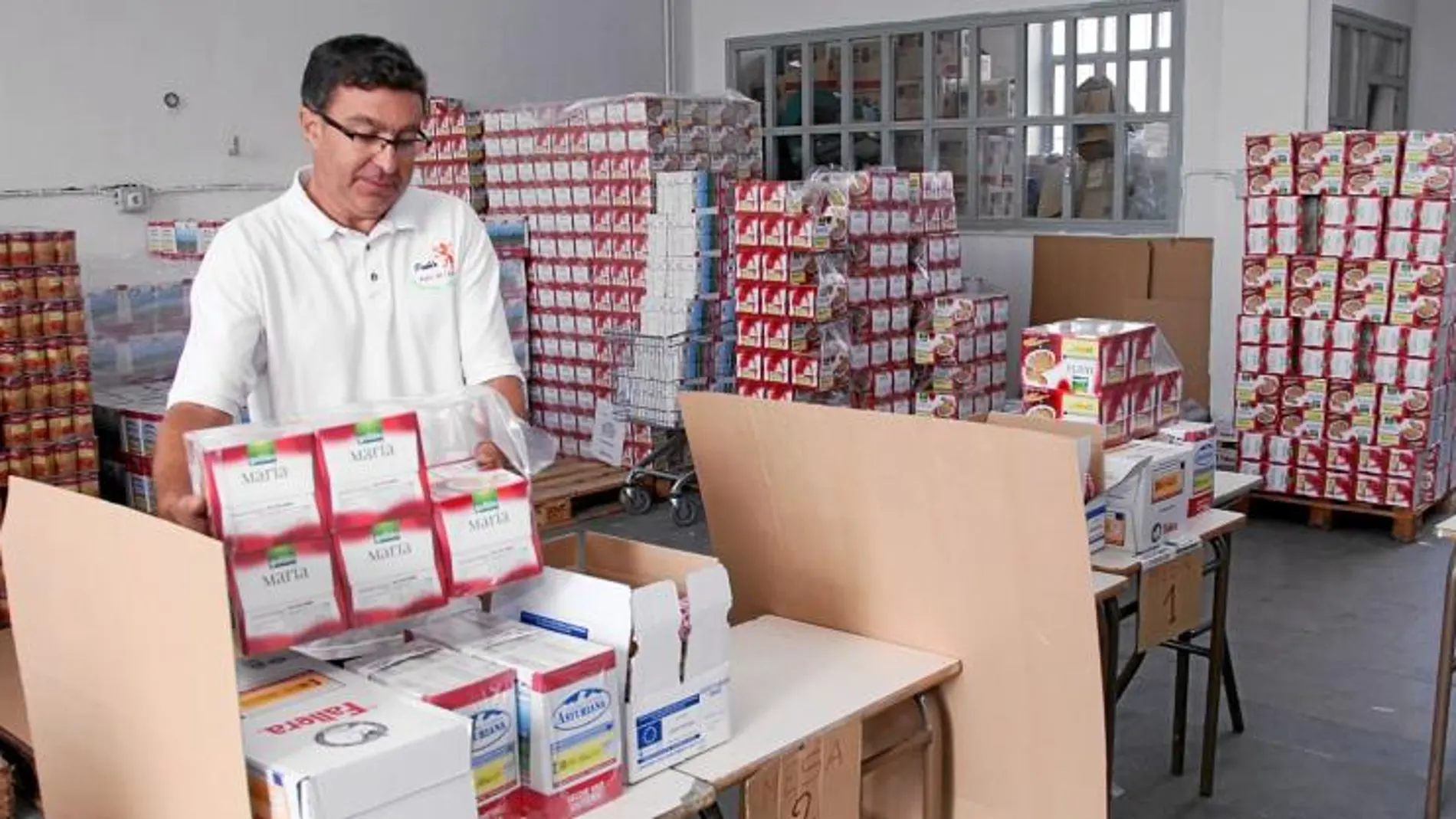 Voluntario del Programa de Alimentos Solidarios de León, colocando lotes de comida para distribuirlos a partir de hoy a cientos de familias