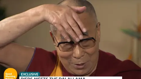 El Dalai Lama durante su imitación del tupé de Donald Trump
