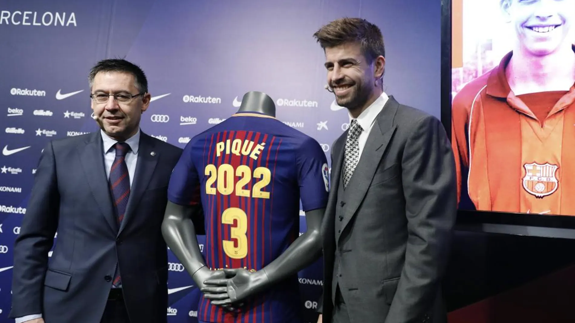 El central del FC Barcelona Gerard Piqué posa con el presidente del club, Josep María Bartomeu, tras firmar su ampliación de contrato con el club azulgrana, en el que permanecerá cuatro temporadas mas.
