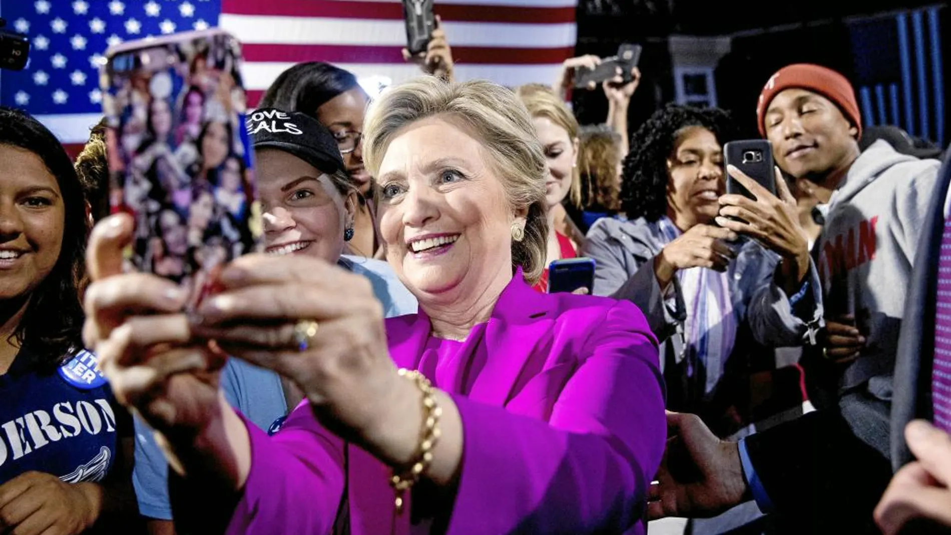 Clinton se hace «selfies» con sus seguidores y detrás el rapero «Jay Z»