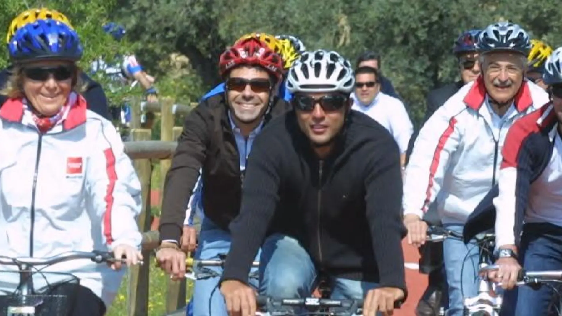 Ciclistas con cascos circulan por un carril-bici