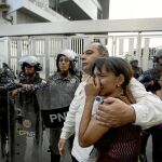 Miembros del partido de Fernando Albán se abrazan ayer a las puertas de la sede del Sebin en Caracas