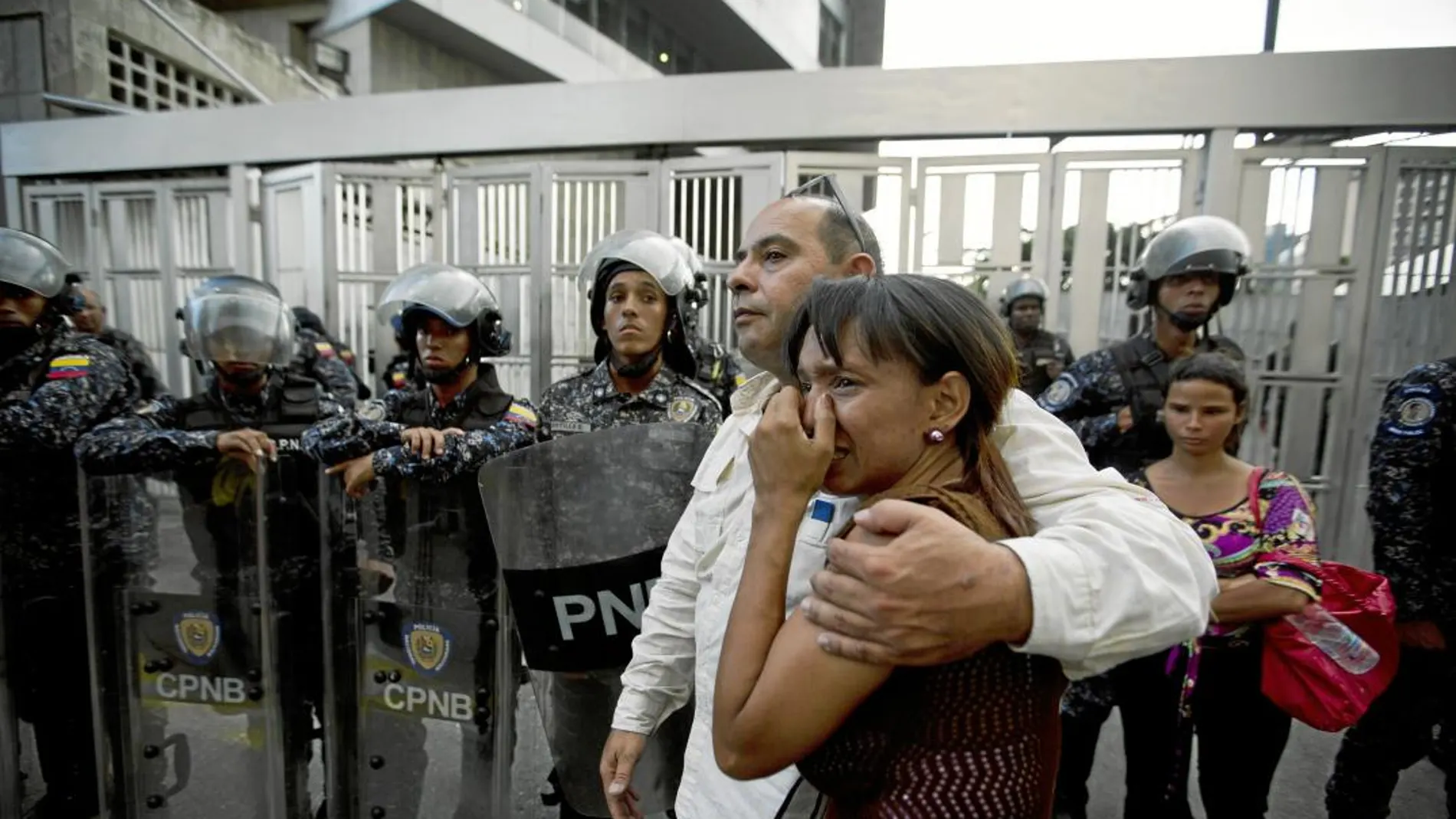 Miembros del partido de Fernando Albán se abrazan ayer a las puertas de la sede del Sebin en Caracas