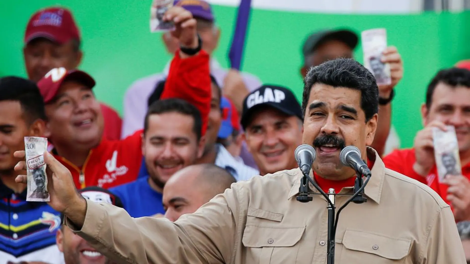 Nicolás Madurocon un billete de 100 bolívares en Caracas este sábado