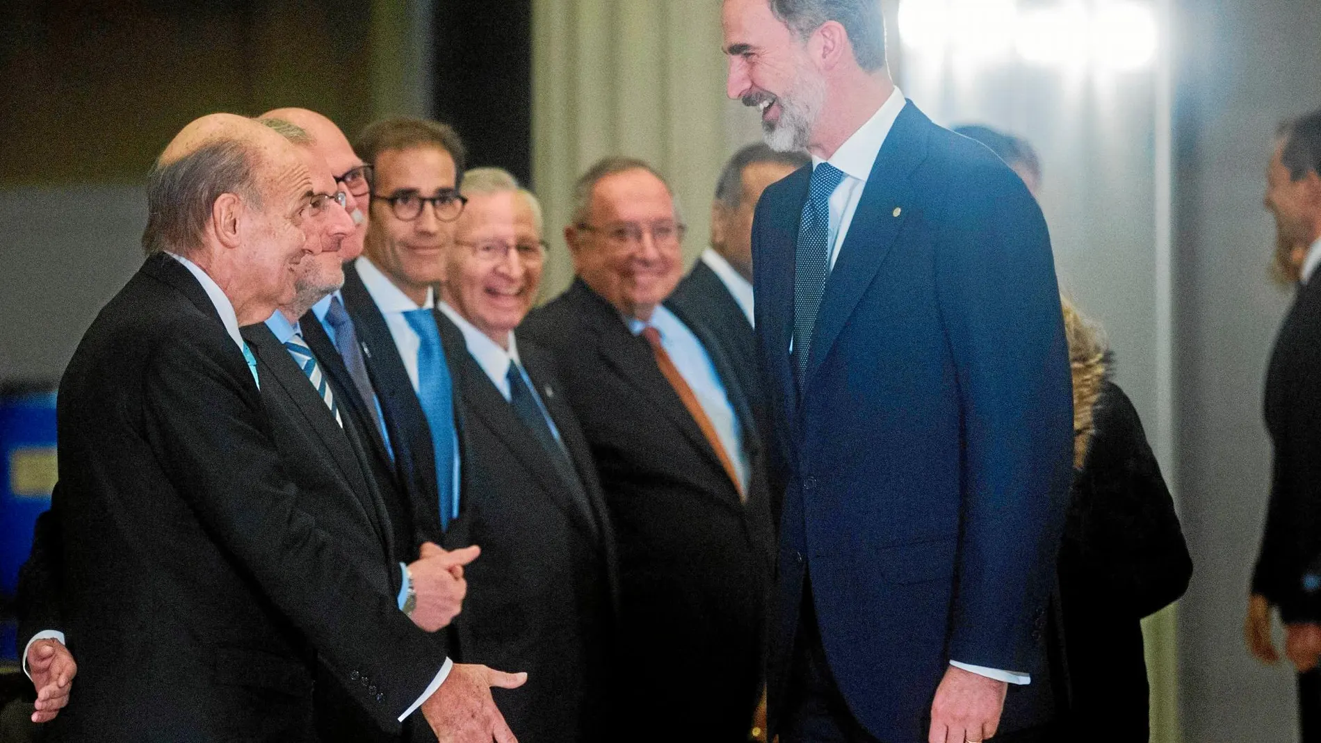 El rey Felipe VI saluda a Miquel Roca (i), uno de los padres de la Constitución, a su llegada a la cena de inauguración del Mobile World Congress (MWC) / Efe