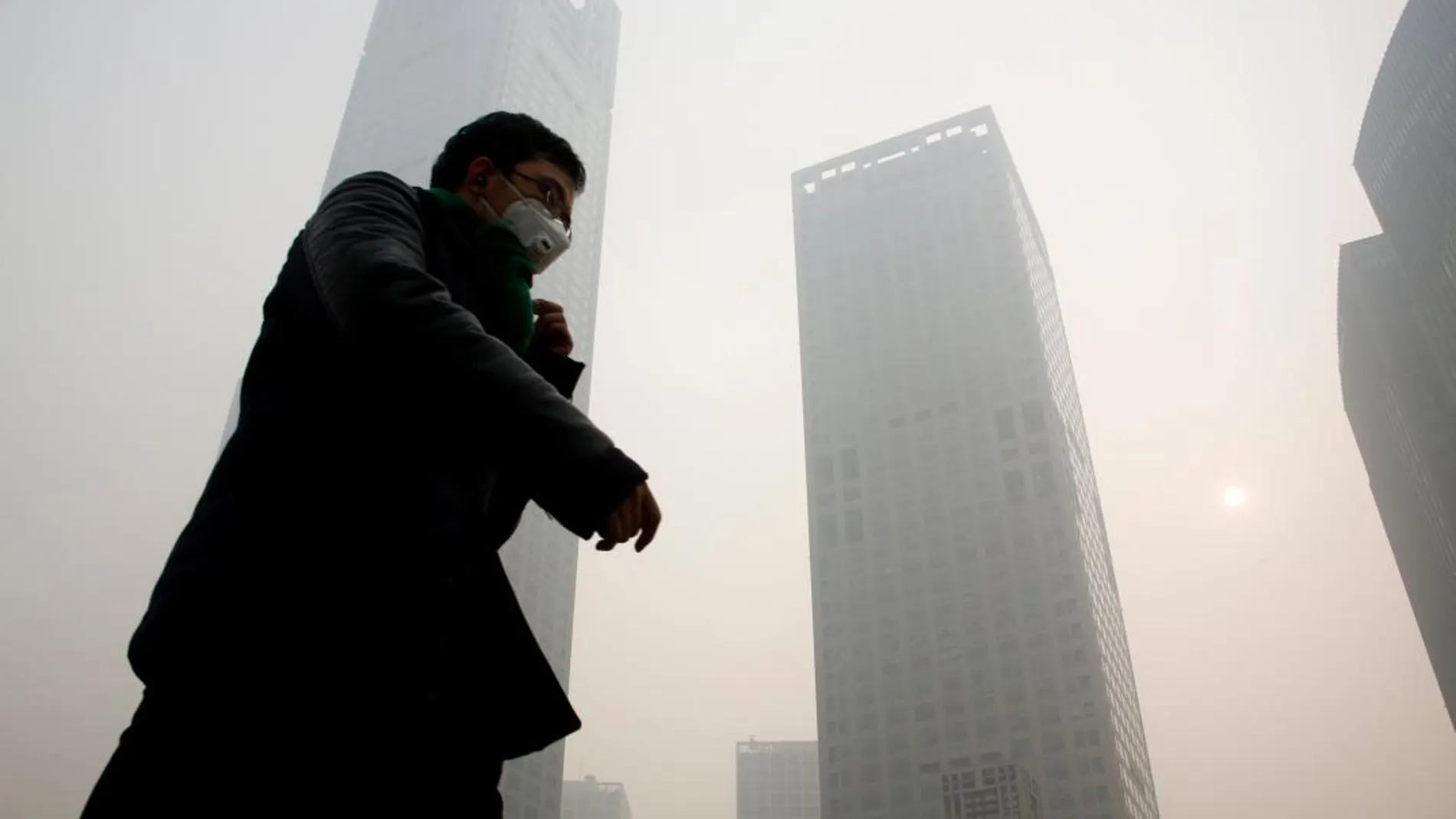 Un peatón se protege con una máscara de la contaminación en Pekín / Reuters