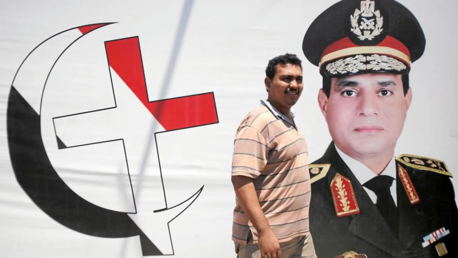 Un partidario del golpe del Ejército camina ante un cartel del general Al Sisi en El Cairo