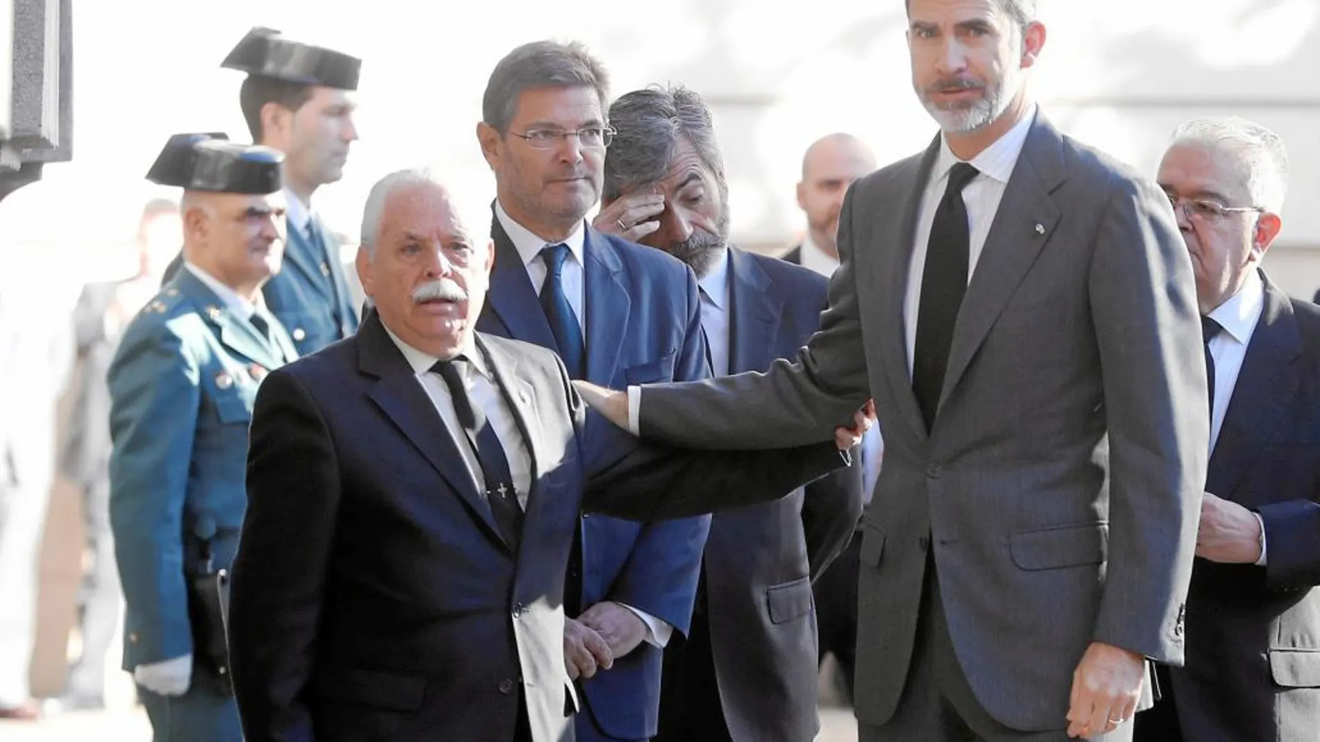 El Rey junto al ministro de Justicia, Rafael Catalá, y el fiscal en funciones, Luis Navajas, ayer en el funeral de Maza