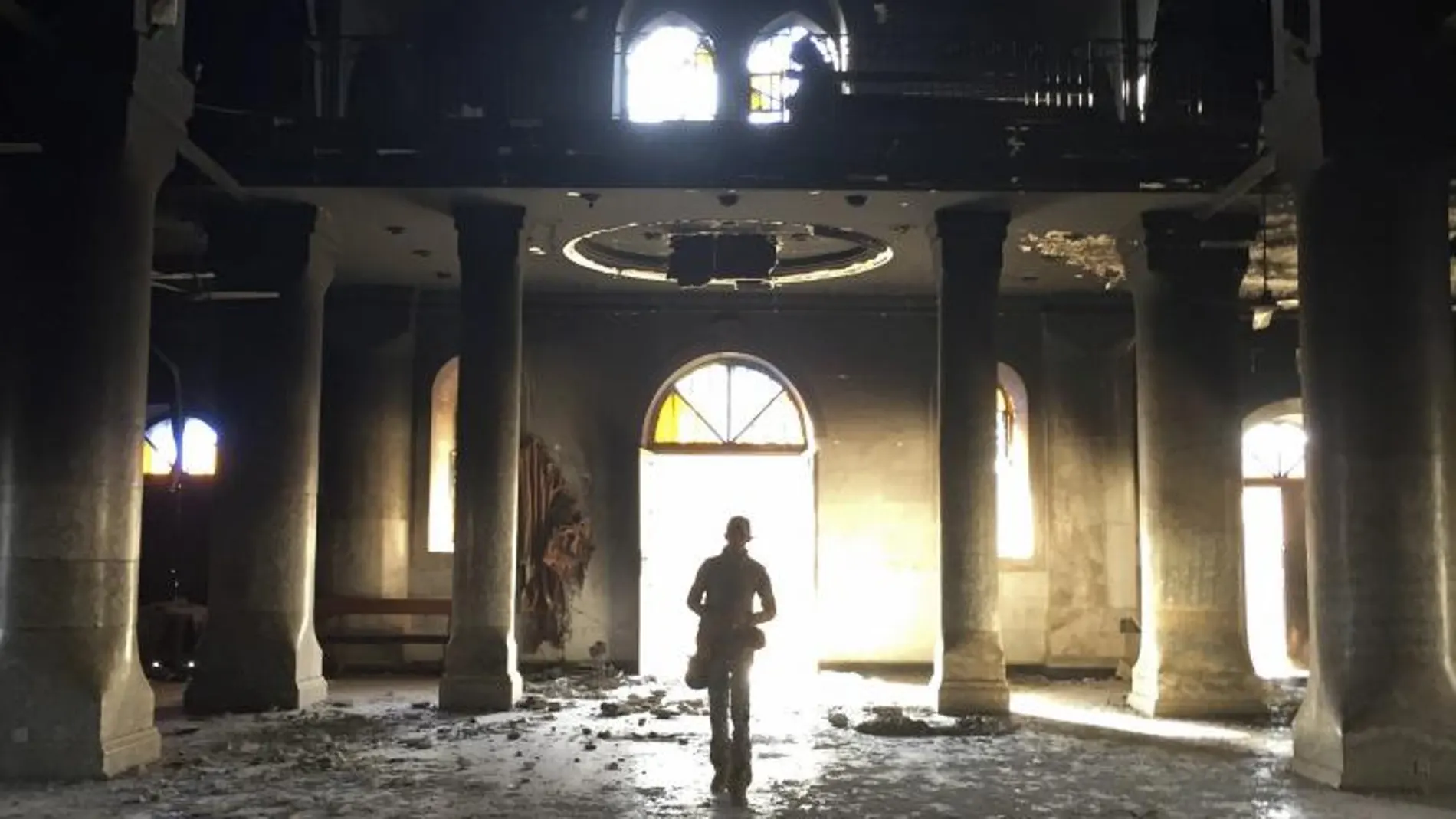 Un soldado camina por la iglesia de Al Tahira (Inmaculada), destrozada por el grupo yihadista Estado Islámico, en la de la localidad de Al Hamdaniya