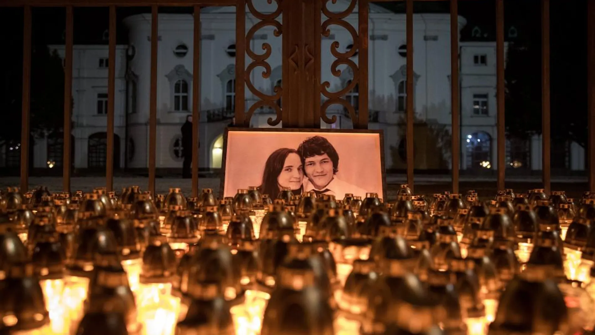 Un grupo de personas enciende velas antes de participar en una marcha en memoria del periodista eslovaco Jan Kuciak, asesinado junto a su novia Martina, frente a la sede del Gobierno en Bratislava (Eslovaquia) ayer