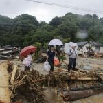 Residentes observan un camino colapsado en el distrito devastado por un derrumbe de tierra en Asakura, Fukuoka, (Japón)