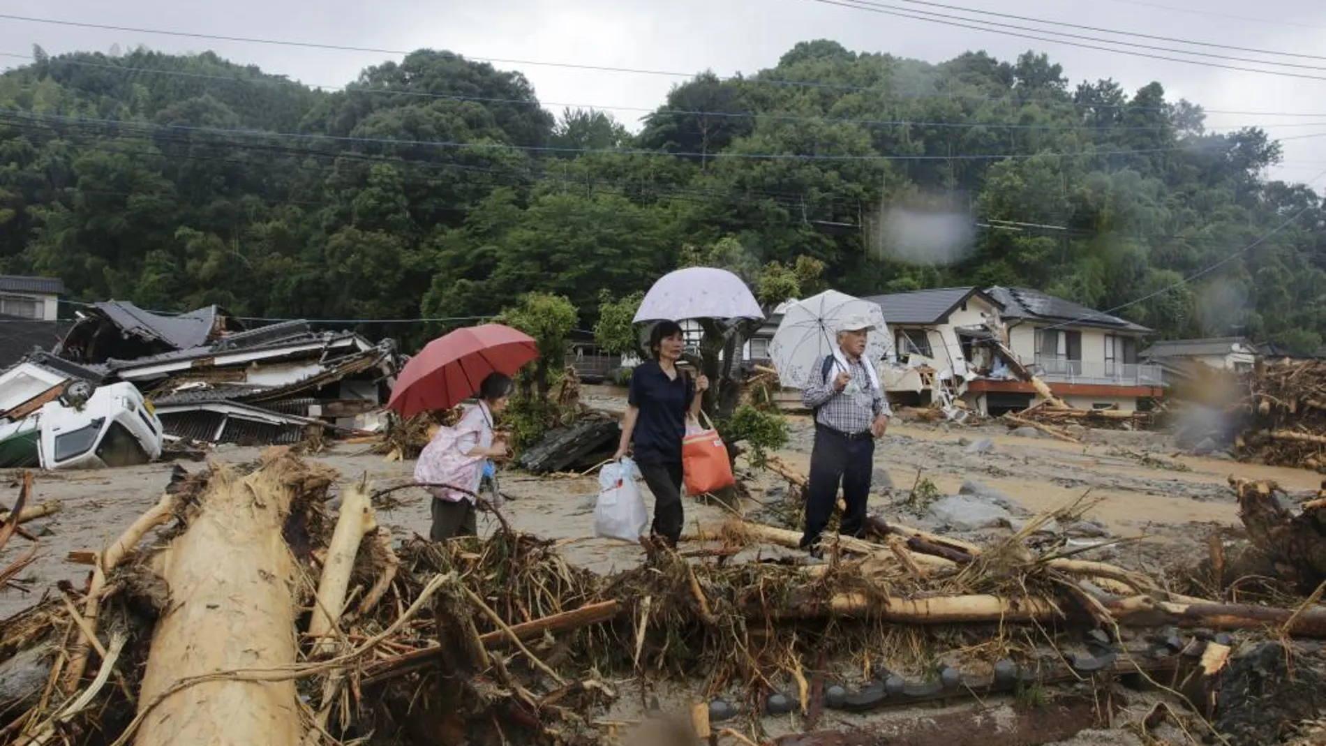 Residentes observan un camino colapsado en el distrito devastado por un derrumbe de tierra en Asakura, Fukuoka, (Japón)