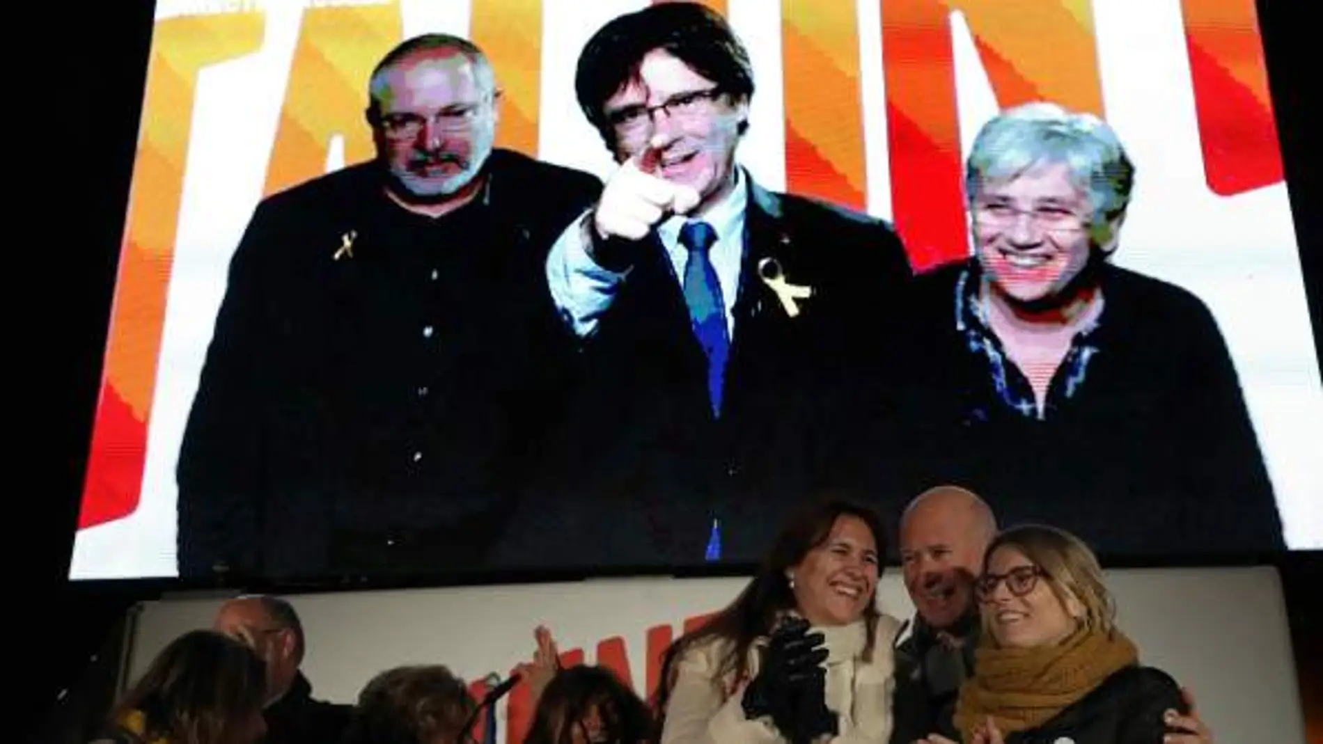 Carles Puigdemont, en pantalla desde Bruselas en el acto final de campaña de JxCat / Efe