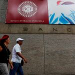Dos personas caminan junto al Banco Central de Venezuela, de donde ha salido el oro/Reuters