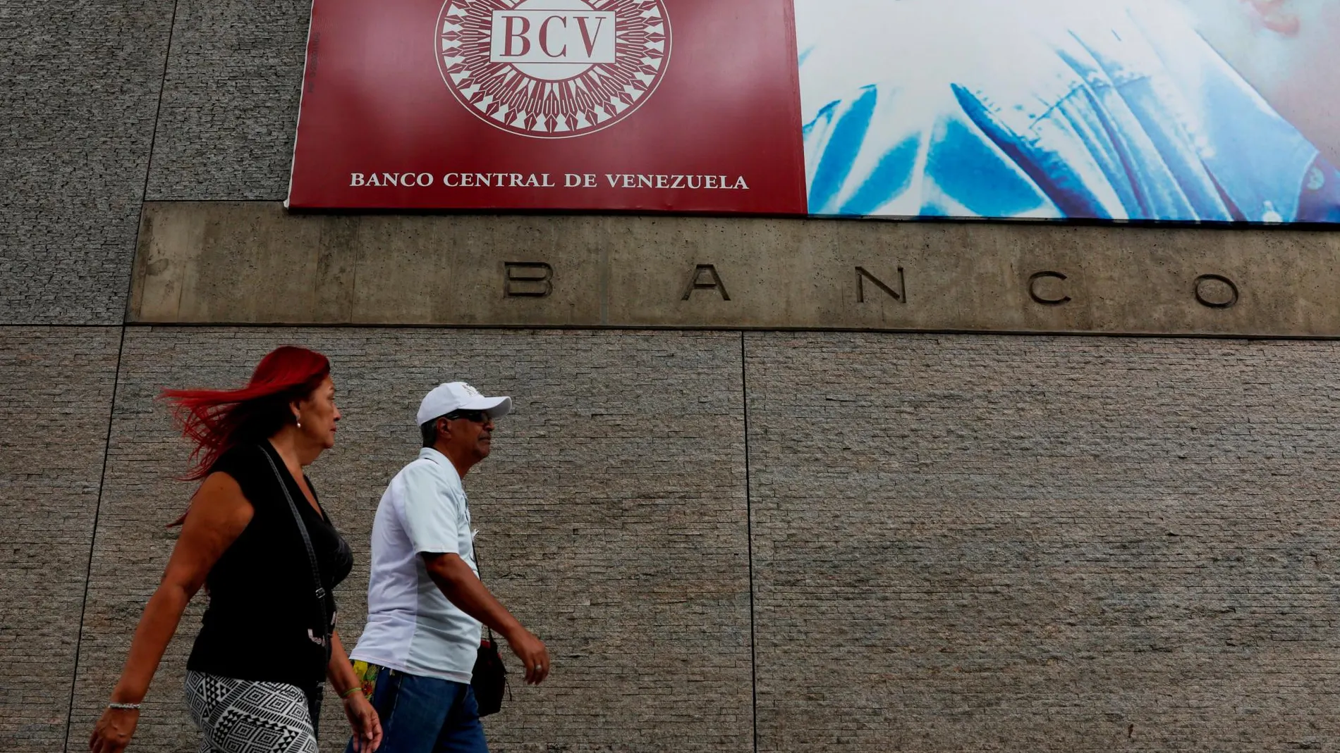 Dos personas caminan junto al Banco Central de Venezuela, de donde ha salido el oro/Reuters
