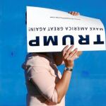Una mujer con un cartel de la campaña de Donald Trump en la ciudad de San José, en California