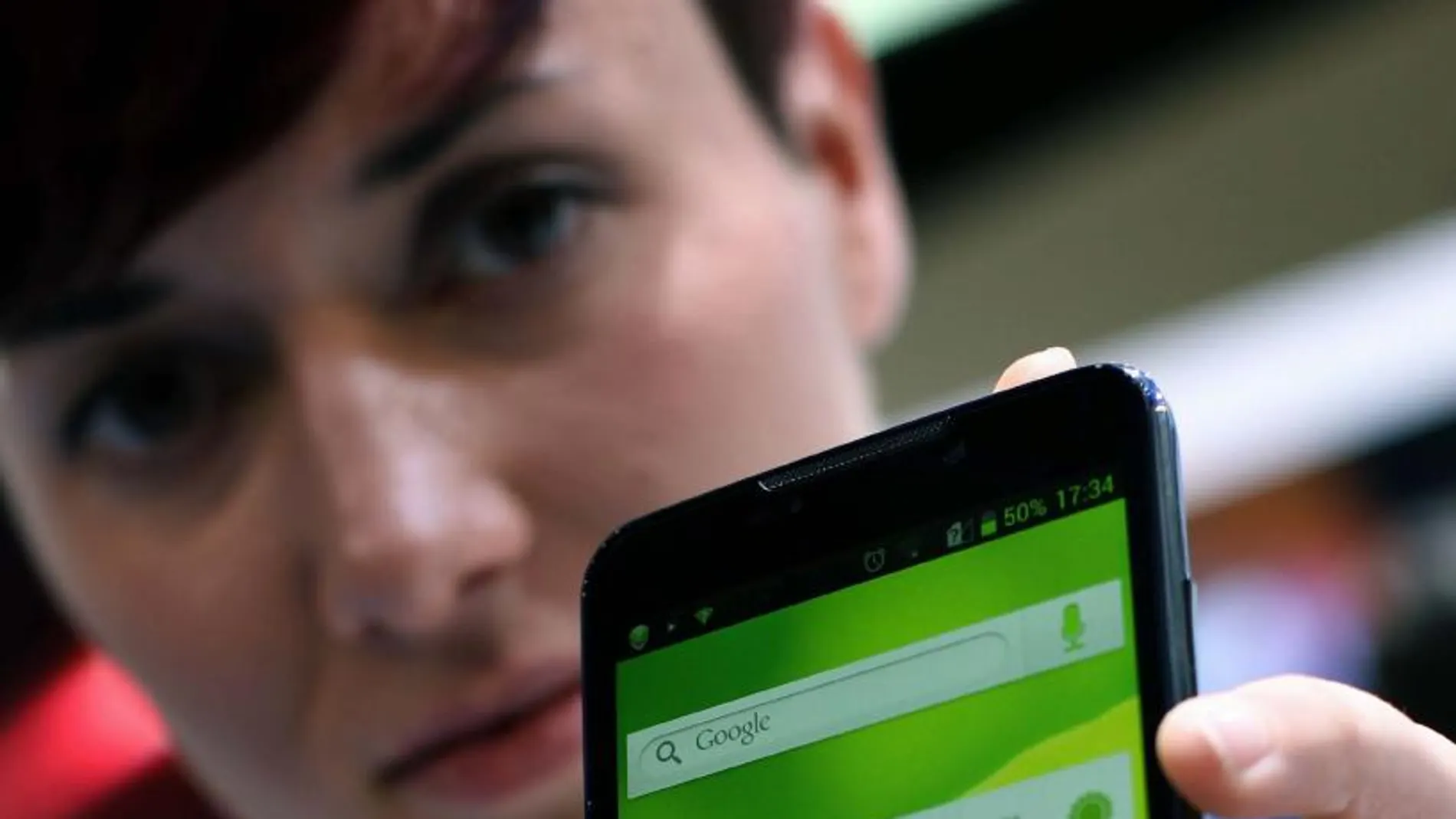 Una mujer muestra su smartphone ZTE Grand Memo de 5,7"de pantalla.