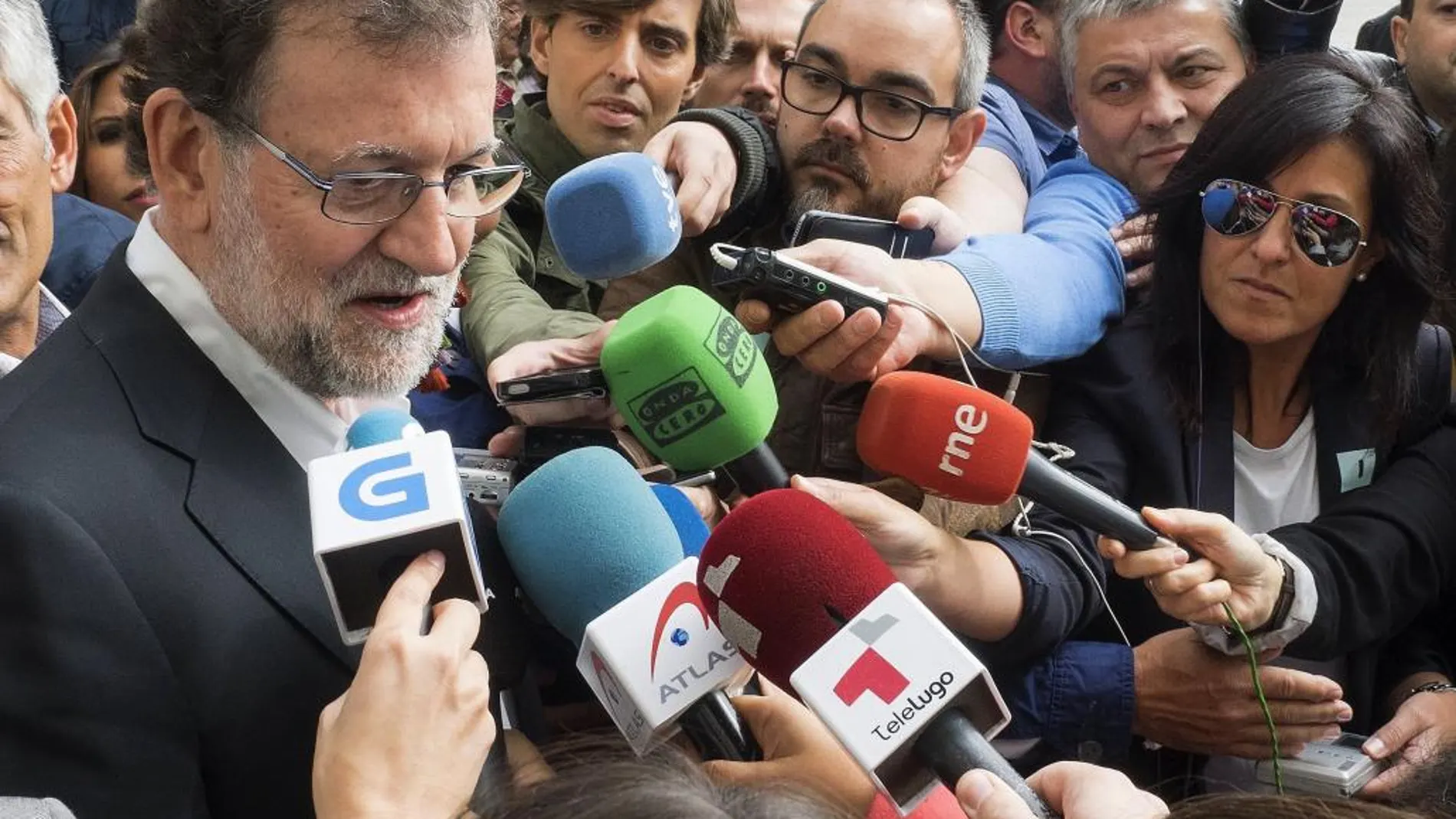 El presidente del PP y del Gobierno en funciones, Mariano Rajoy, atiende a los medios durante el paseo electoral que ha protagonizado hoy en Lugo