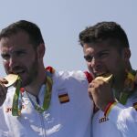 A la izquierda, Saúl y a la derecha, Cristian, mordiendo la medalla de oro tras su victoria en la prueba de kayak doble en 200 metros
