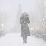 Una mujer camina por la calle durante una tormenta de nieve en Rusia