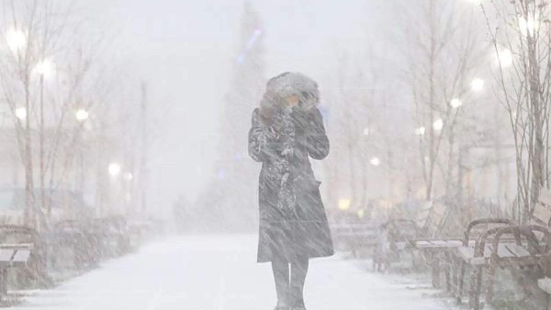 Una mujer camina por la calle durante una tormenta de nieve en Rusia