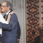 Quim Torra, acompañado del presidente del Parlament, Roger Torrent, saluda a su esposa después de tomar posesión como presidente de la Generalitat, ayer en Barcelona / Ap