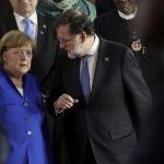 Mariano Rajoy conversa con la canciller alemana, Angela Merkel, durante la foto de familia de los asistentes a la V cumbre Unión Africana-Unión Europea que se celebra en Abiyán (Costa de Marfil)