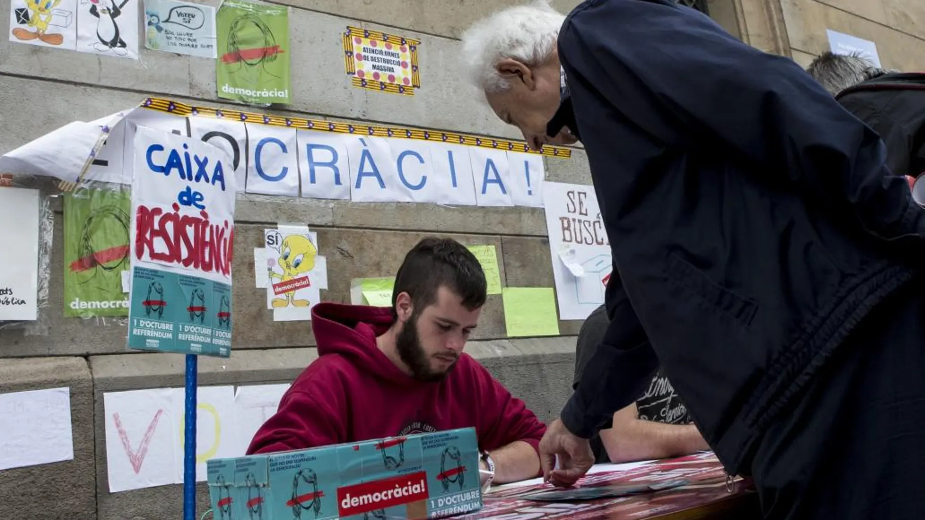 Estudiantes a las puertas de la Universidad de Barcelona ayudan a la gente a saber sus colegios