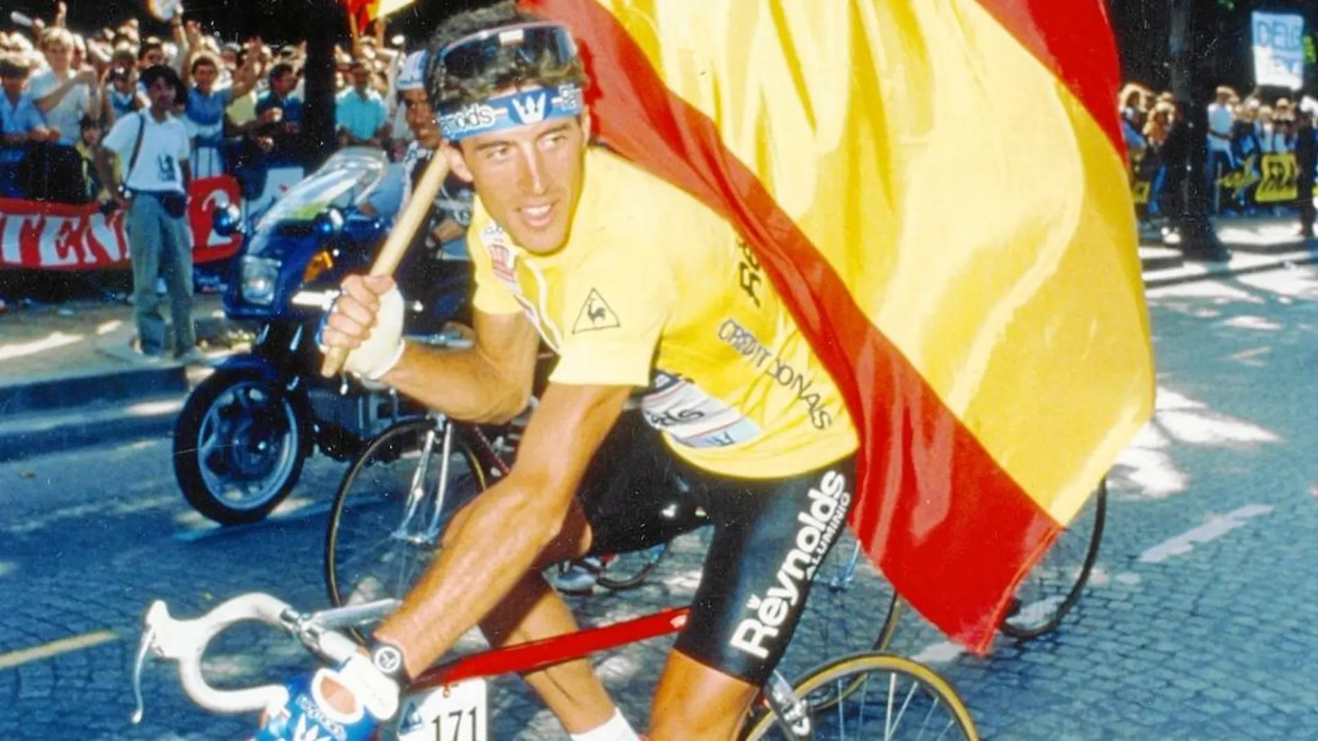 Pedro Delgado vestido de amarillo y con la bandera española en París, el día de su triunfo en el Tour, el 24 de julio de 1988