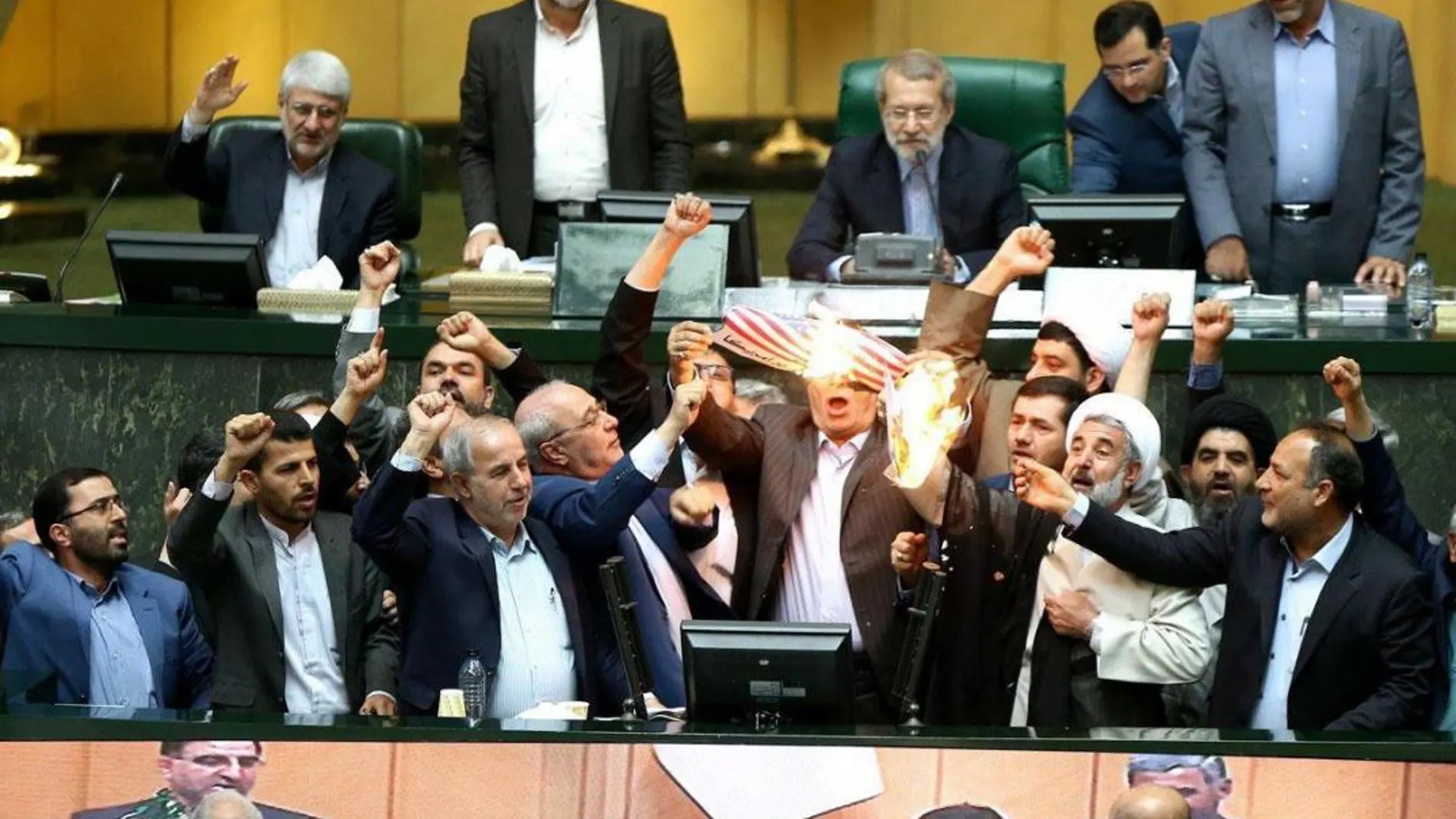 Un grupo de diputados iraníes queman una bandera de EE.UU. en protesta por la decisión del presidente estadounidense, Donald Trump, de retirarse del pacto nuclear. Efe