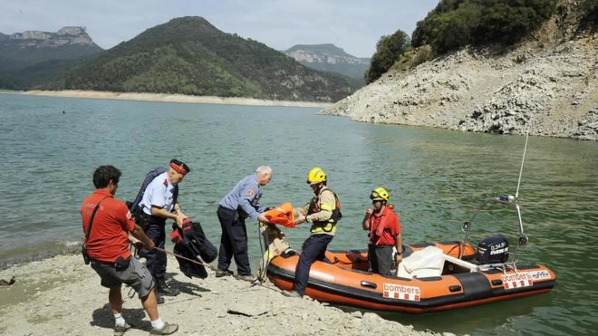 Los Mossos y los bomberos en el momento en el que recuperaron los cuerpos.