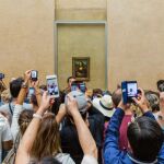 Los turistas fotografiando el cuadro de la Mona Lisa, en París/dreamstime