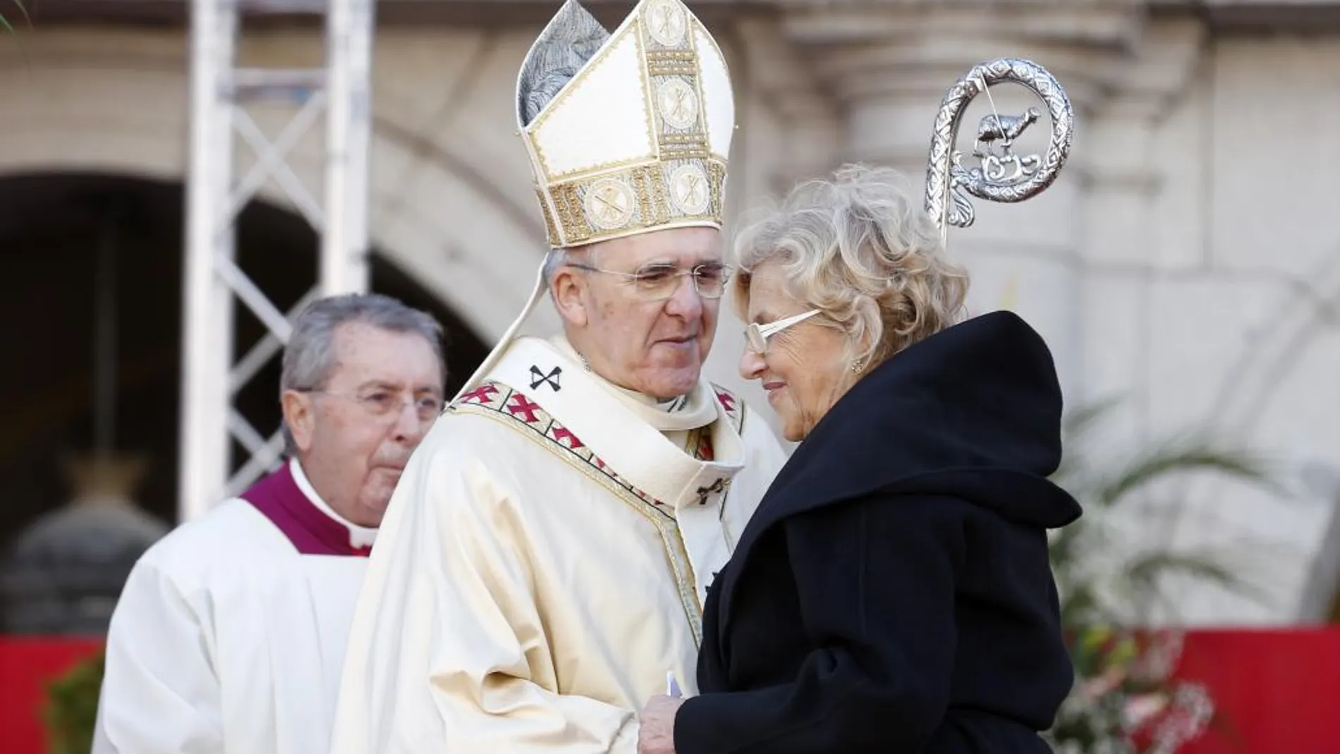 La alcaldesa de Madrid, Manuela Carmena, saluda al arzobispo de Madrid, Carlos Osoro, durante la misa en honor a la patrona de Madrid, la Virgen de la Almudena