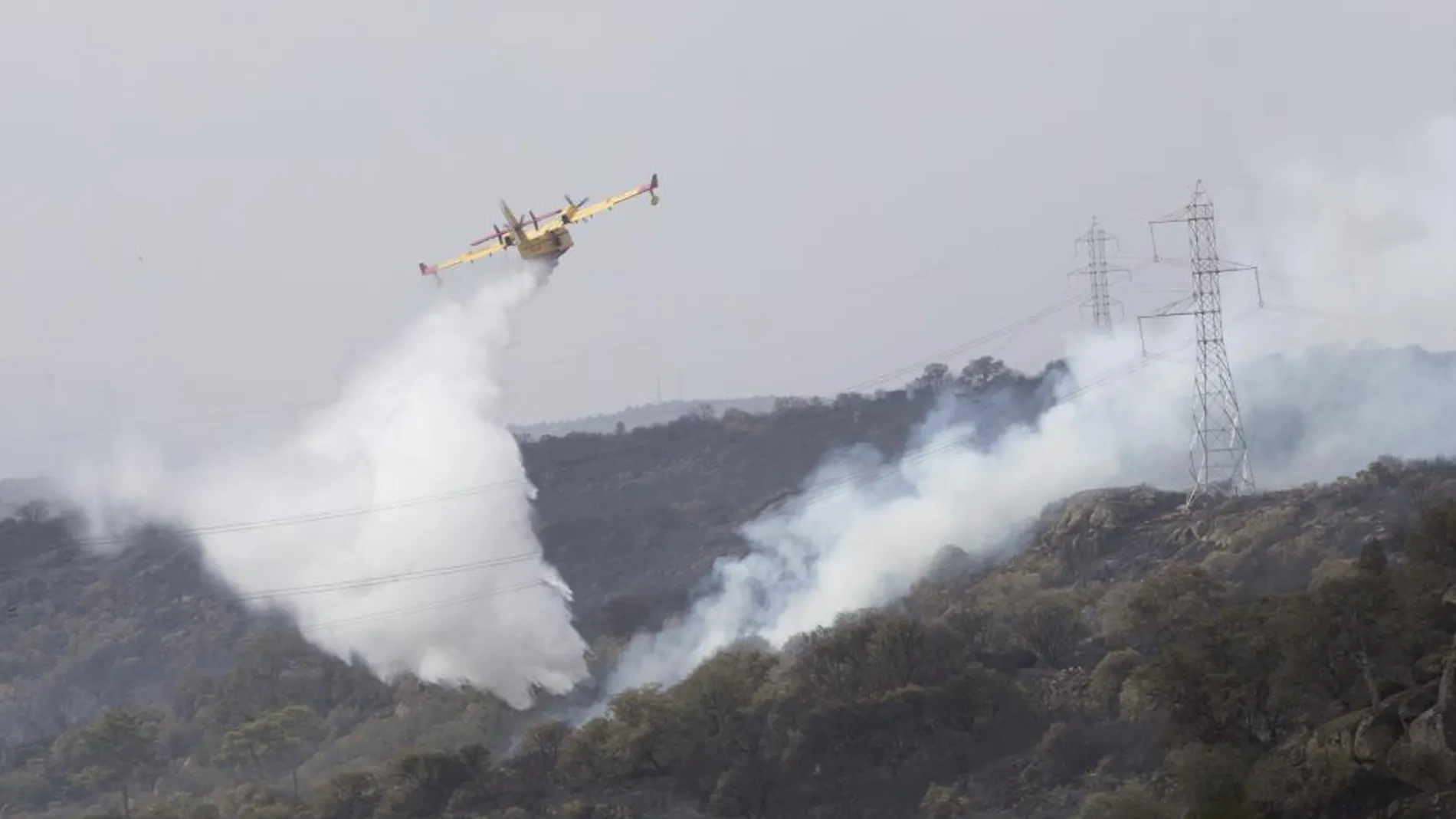 Una avioneta lanza agua en una de las zonas afectadas por el fuego en Fermoselle