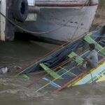 Miembros de los servicios de rescate abordan un barco de pasajeros hundido en el río Chindwin