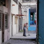 Un hombre barre una acera del centro de La Habana