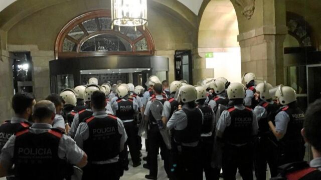 Una de las imágenes del 1-O que más impacto ha tenido es la de un grupo de Mossos entrando a toda prisa a la Cámara catalana para refugiarse y esperar refuerzos, como se ve en la imagen. Los antidisturbios disponibles para la jornada estaban en las movilizaciones ante la Policía Nacional y en Gerona