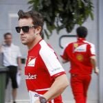 Alonso corre para protegerse de la lluvia en el circuito de Sepang