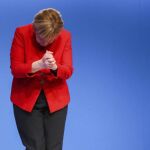 Angela Merkel muestra una papeleta de votación durante el congreso federal de su partido