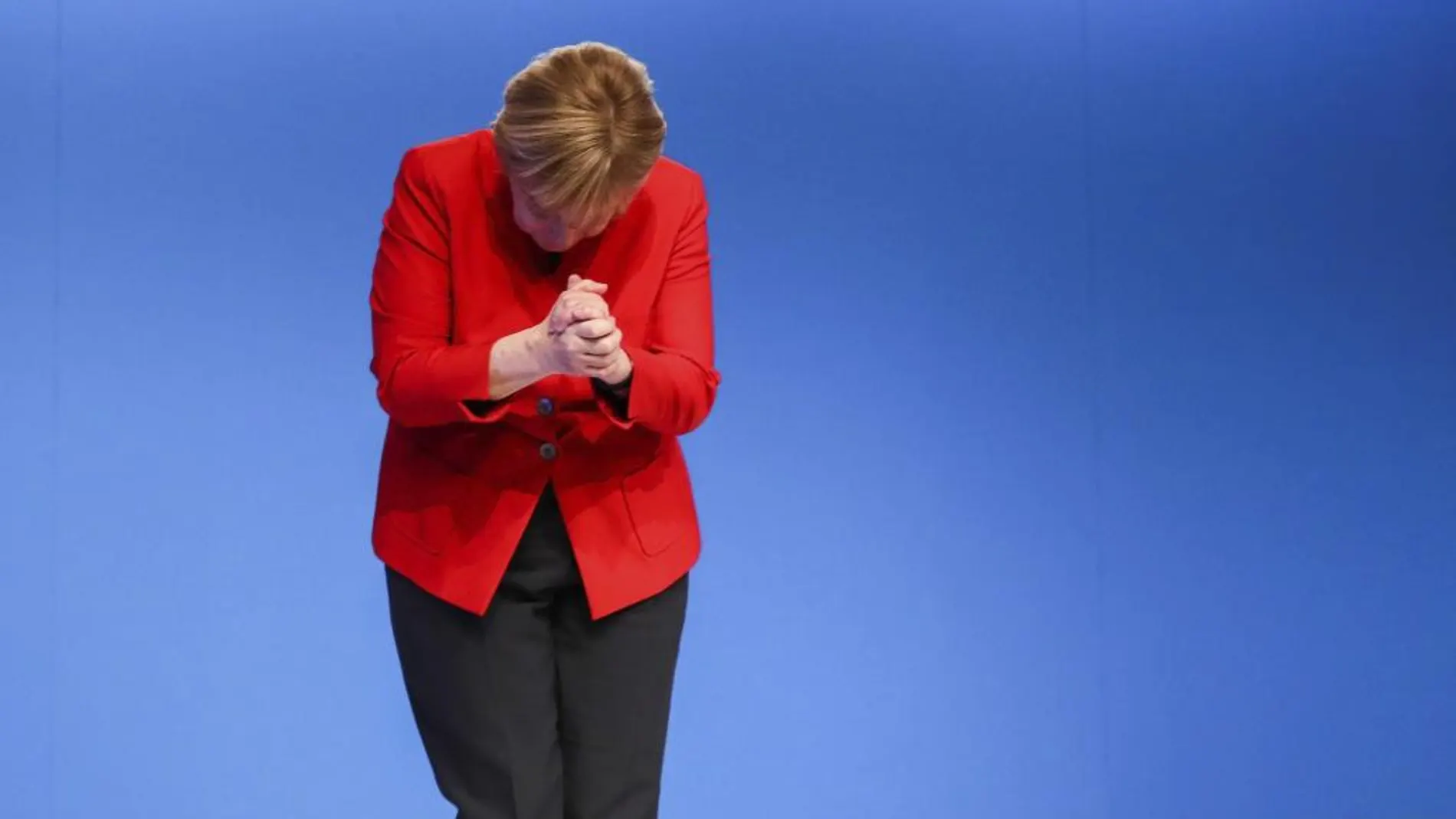 Angela Merkel muestra una papeleta de votación durante el congreso federal de su partido