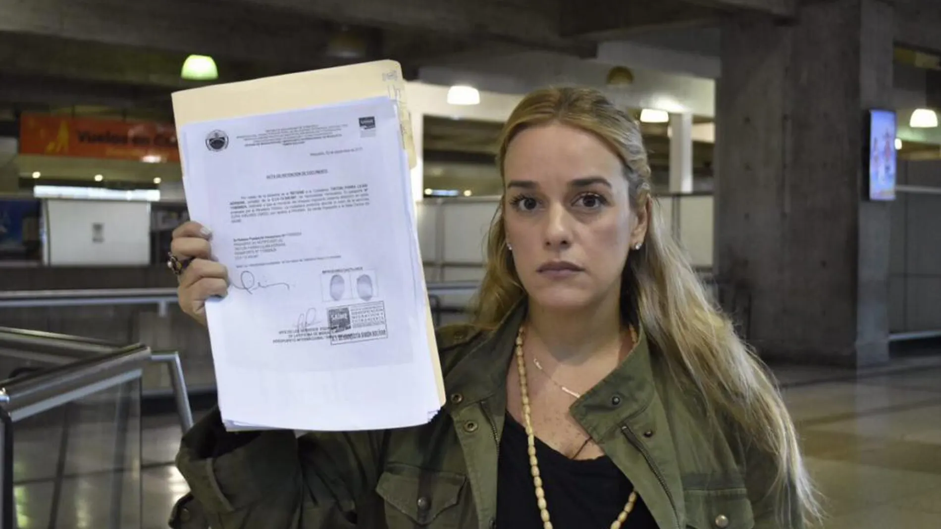 Lilian Tintori, esposa del opositor venezolano Leopoldo López, muestra los papeles que le impiden salir del país.
