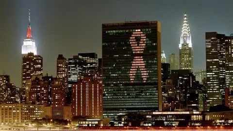 Iluminación del edificio de la sede de la ONU con la cinta roja del sida para demostrar el compromiso de la Organización en la lucha contra el VIH/SIDA
