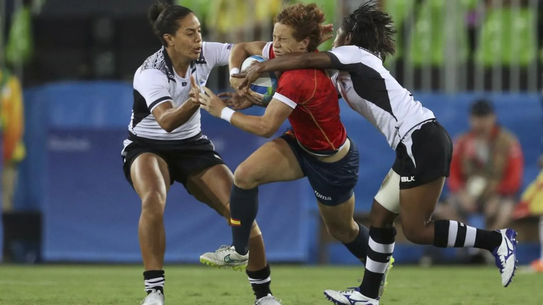 Las jugadores de Fiji, Rebecca Tavo y Ana Maria Roqica tratan de parara a la española Barbara Pla, durante el partido