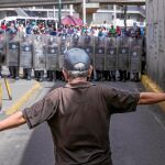 Un hombre protesta ayer en las calles de Caracas frente a la Policía Bolivariana en una manifestación por la falta de alimentos y los cortes de gas, agua y electricidad que sufren varias zonas del país. También la gasolina ha sido racionada y escasea el dinero en efectivo