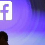 Mark Zuckerberg pasa por delante del logotipo de Facebook