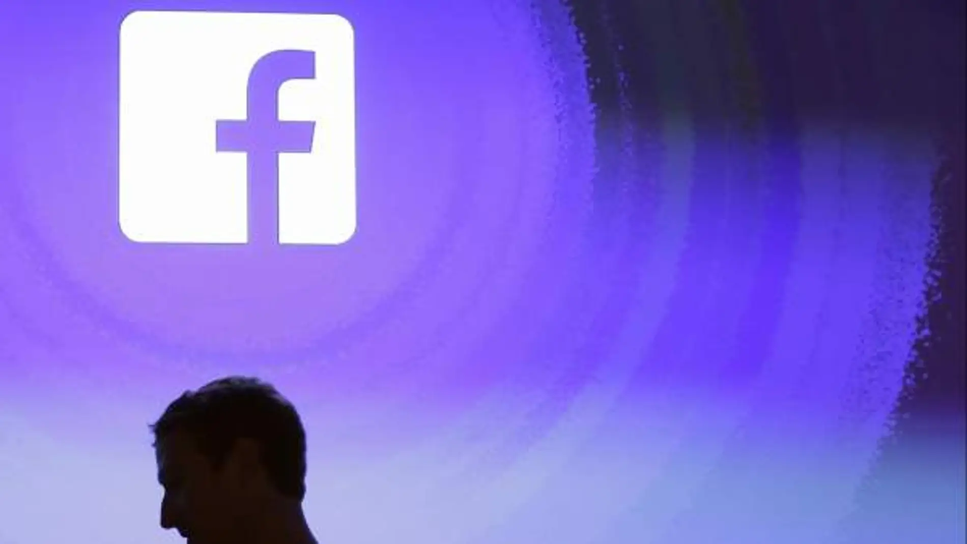 Mark Zuckerberg pasa por delante del logotipo de Facebook