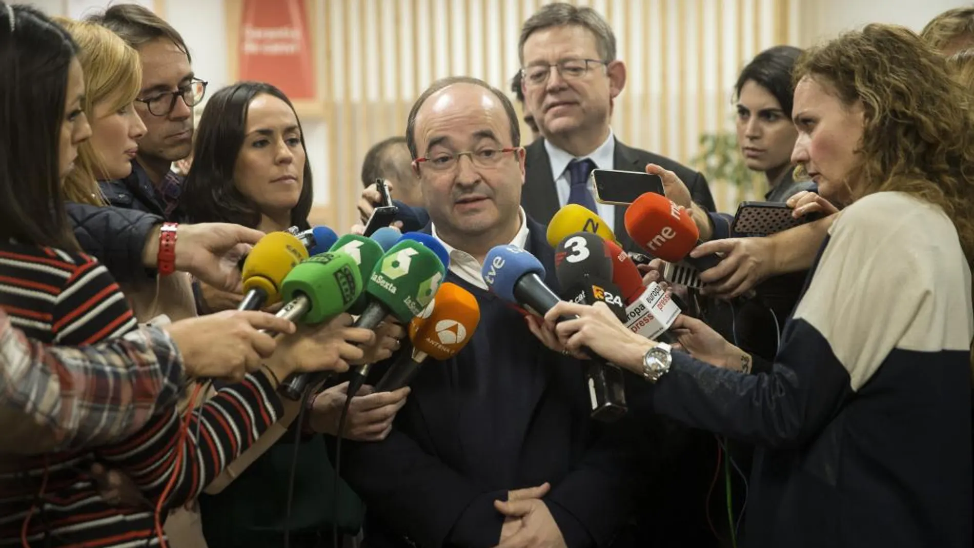 Miquel Iceta atiende a la prensa tras reunirse con el secretario general del PSPV, Ximo Puig (detrás)